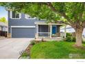 Charming two-story home with a well-maintained lawn, blue accents, and an attached two-car garage at 1672 Maccullen Dr, Erie, CO 80516
