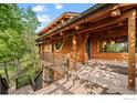 Log home elevation featuring outdoor deck and steps leading to the ground at 172 Tall Pine Ln, Boulder, CO 80302