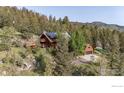 Secluded multi-level log home on a hillside with mature trees and detached garage at 172 Tall Pine Ln, Boulder, CO 80302