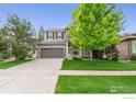Charming two-story home featuring manicured lawn, mature trees, and a neutral color scheme that enhances curb appeal at 17805 Coral Burst St, Parker, CO 80134