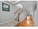 Inviting foyer featuring hardwood floors, a staircase with white risers, and decor that complements the neutral color palette at 17805 Coral Burst St, Parker, CO 80134
