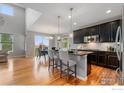Open-concept kitchen and dining area with dark cabinetry, stainless steel appliances, and an island with bar seating at 17805 Coral Burst St, Parker, CO 80134