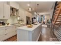 Modern kitchen with stainless steel appliances, white cabinetry, a large island and wood flooring at 2139 N Downing St, Denver, CO 80205
