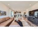 Open-concept living space with modern furnishings, hardwood flooring, and connected kitchen at 2446 W 167Th Ln, Broomfield, CO 80023