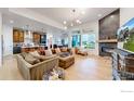 Open-concept living room with fireplace, large windows, and hardwood floors at 2790 Heron Lakes Pkwy, Berthoud, CO 80513
