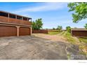 The exterior shows a spacious driveway leading to a two-car garage and a storage shed at 2800 Lake Hollow Rd, Berthoud, CO 80513