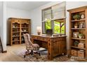 Cozy office space featuring rustic wooden desk, shelves, and bright window offering natural light at 2800 Lake Hollow Rd, Berthoud, CO 80513