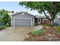 Charming single-story home features a gray exterior, two-car garage, and landscaped front yard at 311 S Adams Dr, Louisville, CO 80027