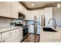 Modern kitchen features stainless steel appliances, gray subway tile backsplash, and light countertops at 410 High Point Dr # 102, Longmont, CO 80504