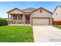 A well kept single Gathering home with stone accents, a two-car garage and beautiful lawn at 466 Freestone St, Brighton, CO 80603