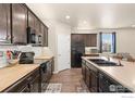Modern kitchen featuring dark cabinetry, butcher block countertops, and stainless steel appliances at 466 Freestone St, Brighton, CO 80603