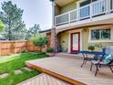Private backyard with wooden deck, lawn, and mature trees, perfect for outdoor living at 4800 Osage Dr # 12B, Boulder, CO 80303