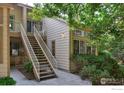 Exterior view of a home with stairs leading to a private entrance and verdant surroundings at 4887 White Rock Cir # D, Boulder, CO 80301