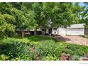 Private backyard with mature trees, flowers, patio, and grassy area at 530 W Hackberry St, Louisville, CO 80027