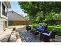 Backyard patio with outdoor furniture, lush green lawn, and mature trees at 530 W Hackberry St, Louisville, CO 80027