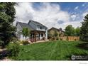 Expansive backyard featuring a lush green lawn, pergola-covered patio, and well-maintained landscaping at 5603 Pierson Mountain Ave, Longmont, CO 80503