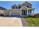 Beautiful gray two-story home showcasing an inviting front porch and a three car garage at 10 N Quantock St, Aurora, CO 80018