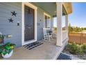 Inviting front porch features rocking chairs, stylish decor and a welcoming 'hello' doormat at 10 N Quantock St, Aurora, CO 80018