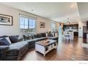 Spacious living room with plush sofa, wood floors, and seamless flow into the dining area at 10 N Quantock St, Aurora, CO 80018