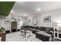 Cozy living room with a large sectional, stylish rug, and curated decor at 10 N Quantock St, Aurora, CO 80018