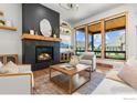 Cozy living room with fireplace, floating shelves, and an abundance of natural light at 1366 Eliza Ave, Berthoud, CO 80513