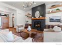 Bright living room features a fireplace, floating shelves, and a stylish light fixture at 1366 Eliza Ave, Berthoud, CO 80513