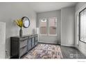Bright entryway features a decorative rug, modern cabinet, and sunny windows at 15998 Humboldt Peak Dr, Broomfield, CO 80023