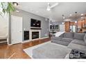 Cozy living room with fireplace, hardwood floors and a comfortable gray sectional sofa at 16031 W 63Rd W Ln # D, Arvada, CO 80403