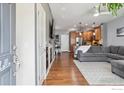 Open-concept living room with a fireplace, hardwood floors, and seamless flow to the kitchen at 16031 W 63Rd W Ln # D, Arvada, CO 80403