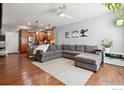 Spacious living room featuring hardwood floors, recessed lighting, and a gray sectional sofa at 16031 W 63Rd W Ln # D, Arvada, CO 80403