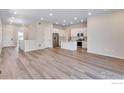 Spacious living room boasts sleek floors and an open layout connecting to a modern, white kitchen at 1790 Mount Meeker Ave, Berthoud, CO 80513