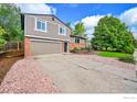 This house boasts an attached two car garage and vibrant landscaping at 2113 Spencer St, Longmont, CO 80501