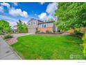 Lovely home featuring a lush green lawn and beautiful mature trees at 2113 Spencer St, Longmont, CO 80501