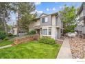 Inviting townhouse with well-kept lawn and ramp, featuring a mix of stucco and gray siding for modern appeal at 2249 Emery St # B, Longmont, CO 80501