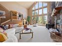 Bright and spacious living room with soaring ceilings, a stone fireplace, and large windows offering picturesque views at 23 Hess Ave, Golden, CO 80401