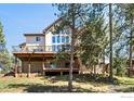 Expansive back deck with stunning views, ideal for outdoor entertaining and relaxation with mature trees at 23 Hess Ave, Golden, CO 80401