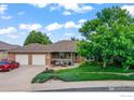 Spacious ranch-style brick home with well-maintained landscaping and an attached two-car garage at 233 Elizabeth Ct, Fort Lupton, CO 80621