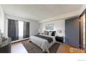 Cozy bedroom with neutral tones, a comfortable king-size bed, and soft natural light from the window at 3526 S Depew St # 102, Lakewood, CO 80235