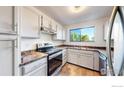 Efficient kitchen featuring white cabinets, modern appliances, and a window with views of the outdoors at 3526 S Depew St # 102, Lakewood, CO 80235