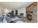 Inviting living room with a stone fireplace, plush seating, and an open layout connecting to the dining area at 3526 S Depew St # 102, Lakewood, CO 80235
