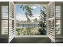 View of tennis court from inside home, through window with open shutters at 4993 Clubhouse Ct, Boulder, CO 80301