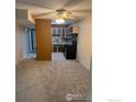 Neutral toned living area with ceiling fan flowing into kitchen at 5102 Williams Fork Trl # 205, Boulder, CO 80301