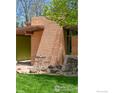 A cozy outdoor seating area complements the architectural brick detail and landscape at 5450 Mohawk Rd, Littleton, CO 80123