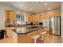 Bright kitchen featuring a center island cooktop, stainless steel appliances, granite countertops, and wood cabinets at 710 Inca Pkwy, Boulder, CO 80303