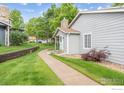 Serene side view of a home with lush green lawn, sidewalk, and mature trees at 8423 Everett Way # A, Arvada, CO 80005