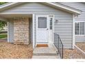 Close-up of the front entrance showing a white door, stone detail, and welcome mat at 8423 Everett Way # A, Arvada, CO 80005