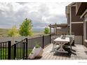 Outdoor deck with dining set, black metal railing, and views of the expansive community at 970 Auburn Dr, Erie, CO 80516