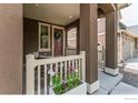 Inviting covered front porch with flower box, a cozy seating area, and stylish brown pillars at 970 Auburn Dr, Erie, CO 80516