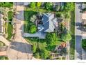 Aerial view of a well-maintained home with a manicured lawn, mature landscaping, and a concrete driveway at 1005 Creek Ct, Longmont, CO 80503