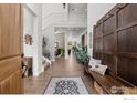 Spacious foyer with hardwood floors, bench, and staircase leading to second floor at 10525 Wild Fox Pl, Franktown, CO 80116